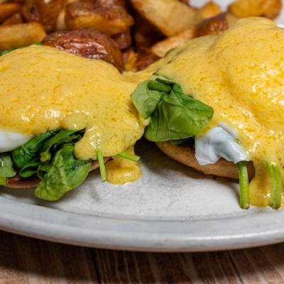 Two poached eggs and spinach on a toasted English muffin.