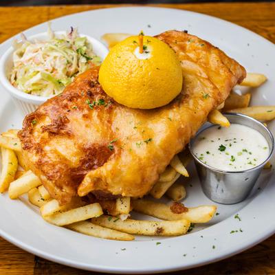 Fish N Chips with a side of dipping sauce and coleslaw.