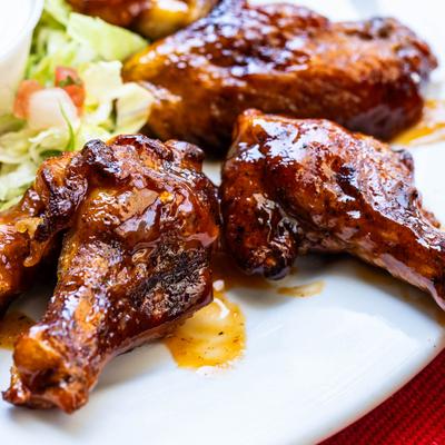 Mango habanero wings with Casa Chapala sweet and spicy sauce, close up.