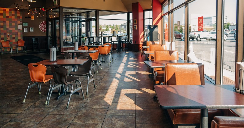Interior, lined up dining tables, and restaurant booths by a window side