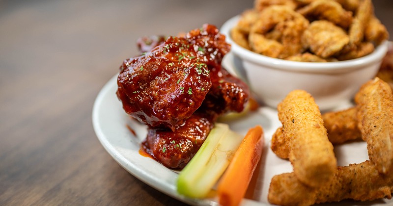 Saucy chicken wings served with mozzarella sticks, carrots, and celery