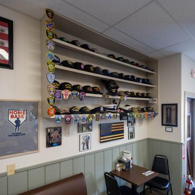 Shelf with various baseball caps and patches.