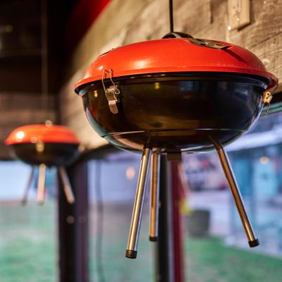 Red grill kettles hanging near a window inside the restaurant.