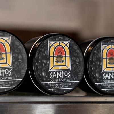 Interior, Santos Coffee Rub cans aligned on a shelf, close up.