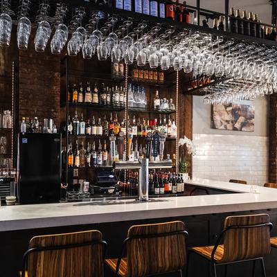 The bar, hanging glasses, bottles on shelves.