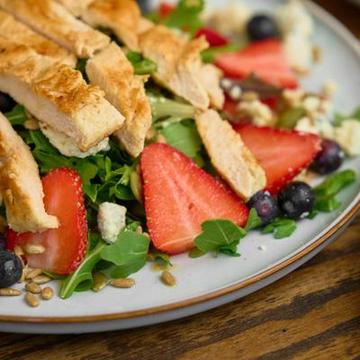 Grilled chicken salad with mixed greens, berries, and blue cheese crumbles.