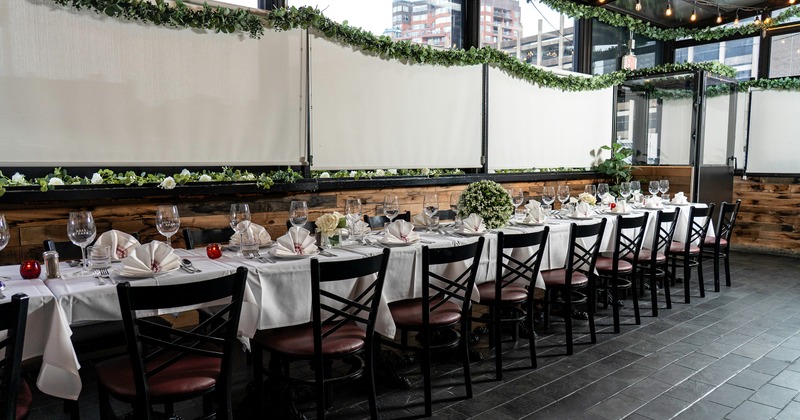 An elegant dining setup in an enclosed patio space with a long set table ready for guests