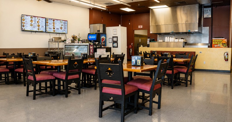 Interior, dining area, tables for four and eight, kitchen in the back, tile flooring