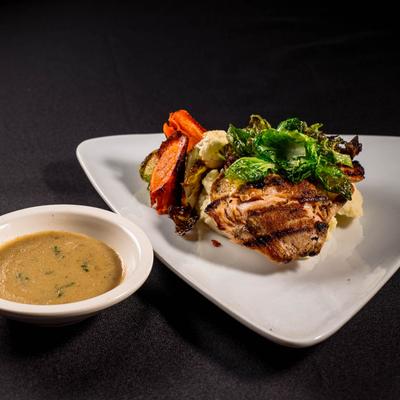 Grilled salmon and grilled vegetables served with a side of grits