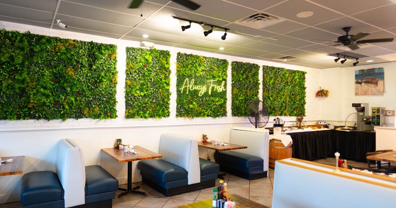 Interior, seating area, seating booths, serving station in the corner, artificial green wall