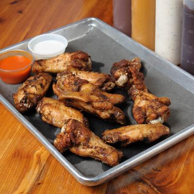Smoked wings served with ranch and hot sauce.