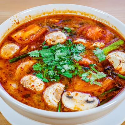 Tom Yum, spicy soup with onion, mushrooms, tomato and cilantro