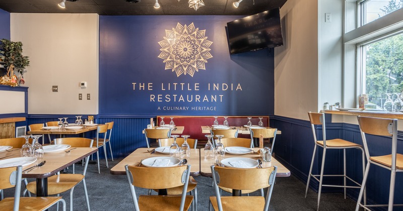 Interior, dining area with one blue wall with the restaurant logo