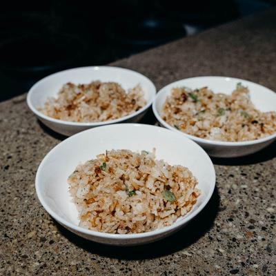 Three bowl of fried rice with herbs.