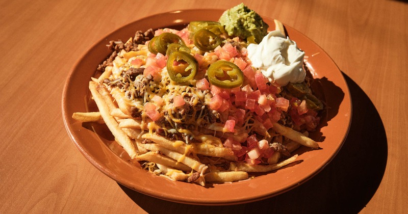 Loaded fries, with beef, diced tomato, jalapenos, sour cream, guacamole, and cheese