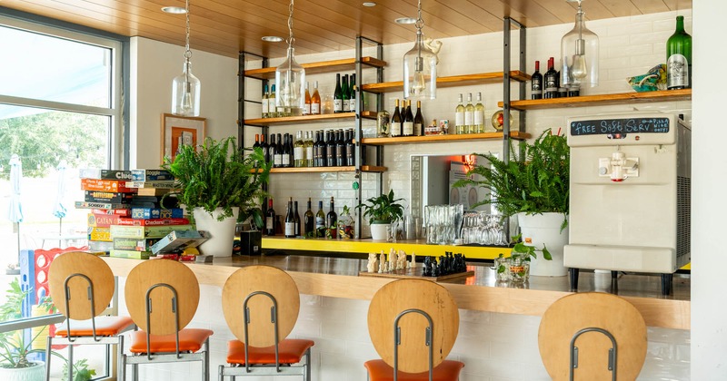 Interior, bar area, wooden top bar with stools, large drink shelf in the back