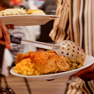 Person platin food with a big spoon.