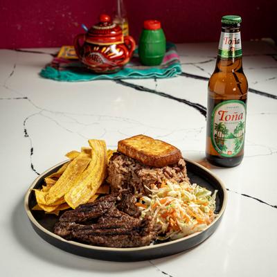 Grilled beef, plantain chips, rice, and slaw.