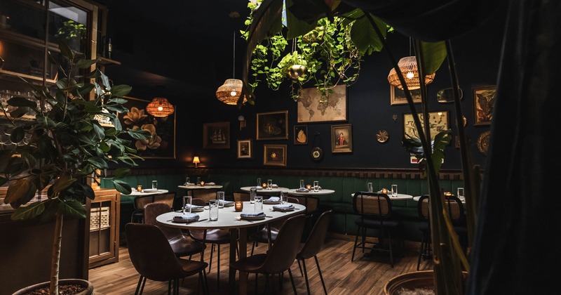 Interior, dining area, set up tables, lavish plant decoration, pictures and paintings on the walls
