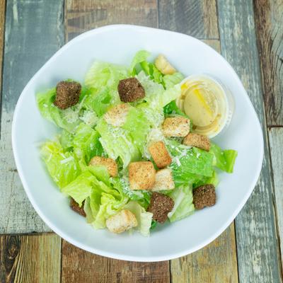 Caesar salad topped with croutons, and Parmesan cheese.