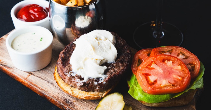 Beef burger with lettuce, tomatoes, fries, and ketchup