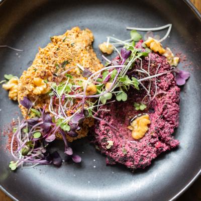 beet and carrot veggie pates called pkhali in Georgian language, on black plate