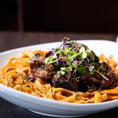Oxtail pasta topped with microgreens.