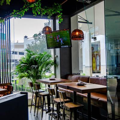 Dining area, tables by the window, TV showing a soccer game.