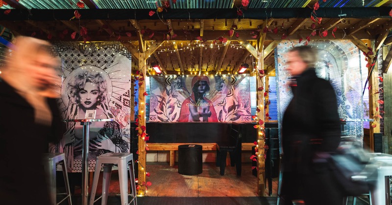 image of an 20 seated outdoor open concept roadway shed in from the front sidewalk of the bar