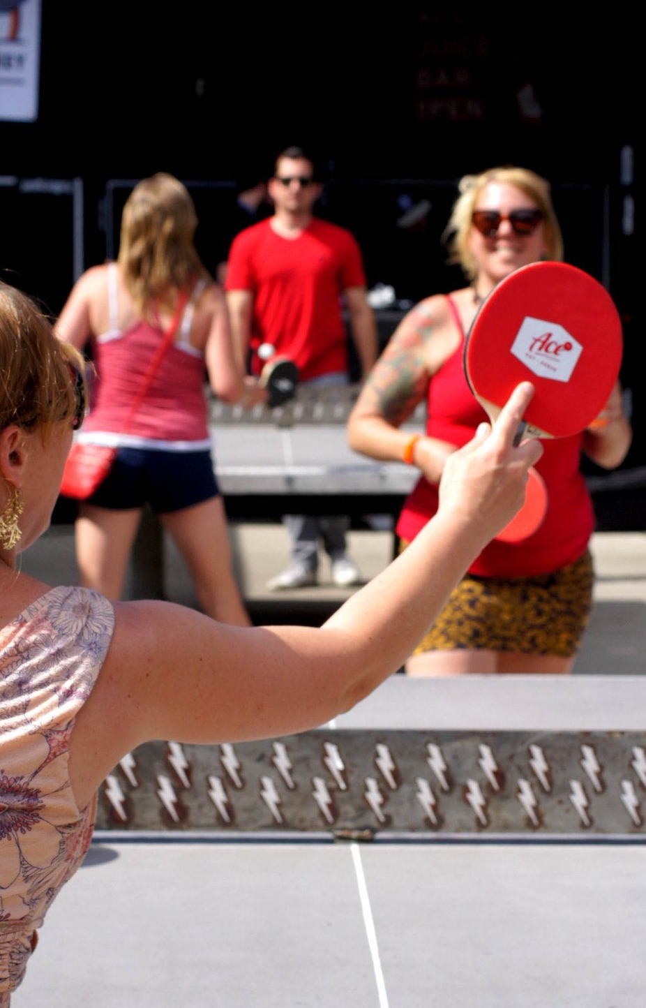 A customer stands with a ping pong paddle in hand, ready to play a game of table tennis.