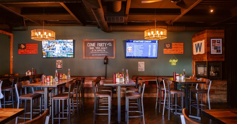 Interior featuring high-top tables, pendant lighting, and multiple televisions