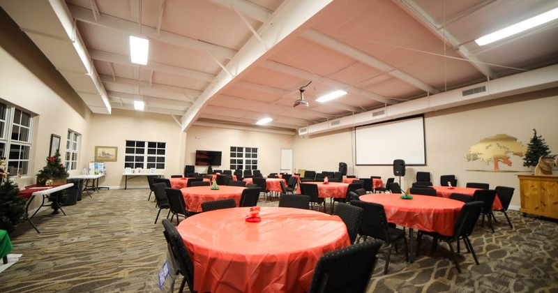 Spacious event hall with round tables, perfect for any private event