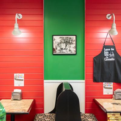 Interior, featuring red and green walls, two tables, and wall decorations.
