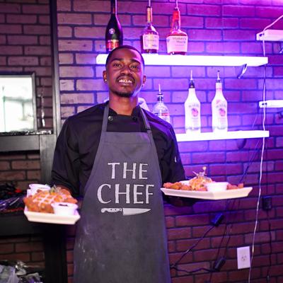 Chef holding trays of food.