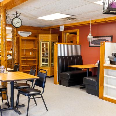 Restaurant dining area with wooden beams, a booth, and tables.