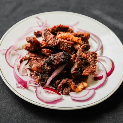 Suya gish with grilled meat and raw onions.