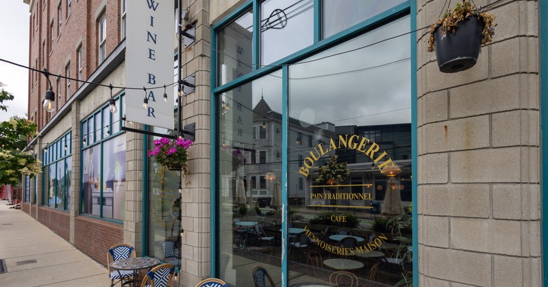 Exterior, side walk, side view to cafe entrance, tables and chairs, sign above