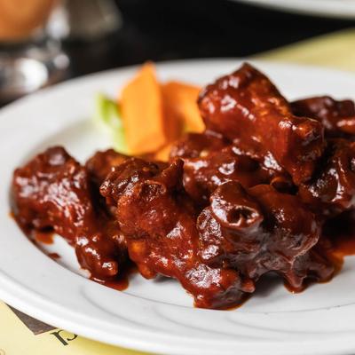 Buffalo wings with sliced carrots on the side.