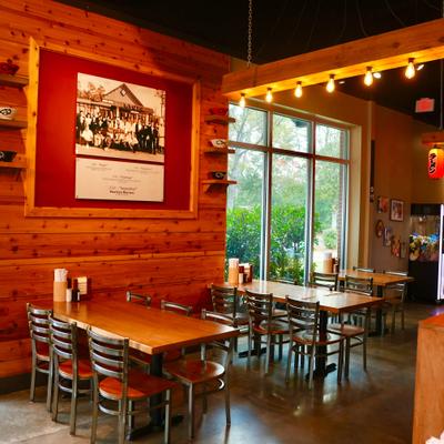 Interior with seating area, wall decorations, extensive wood paneling and Japanese lanterns.