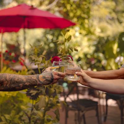 Three people clinking glasses, outdoors.