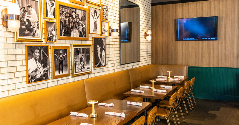 Tables by the brick wall decorate with photos of famous singers