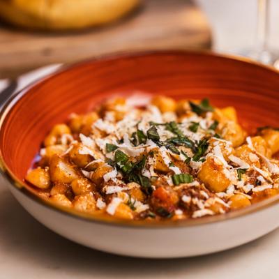 Gnocchi pasta topped with grated cheese and fresh herbs.
