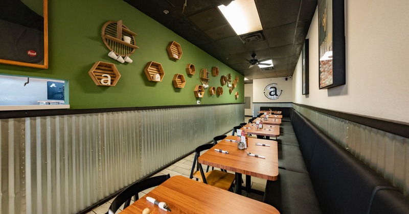 Interior, tables with banquette seating and chairs ready for guests