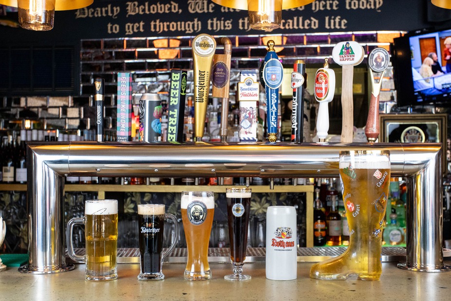 Beer taps lined above the bar counter with filled glasses of beer