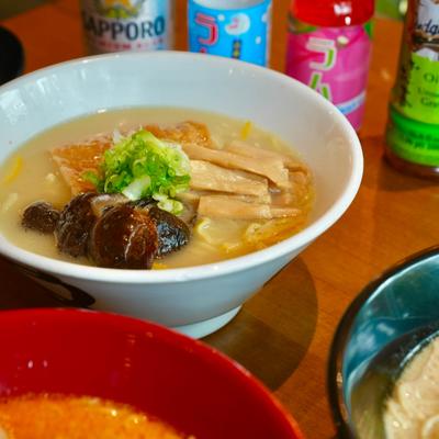 Bowl of ramen topped with pork belly, bamboo shoots, mushrooms and green onions.