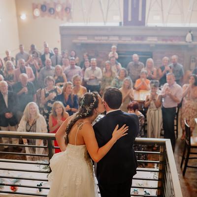 Newlyweds sharing a kiss in front of the guests.