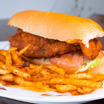 Fried chicken po' boy sandwich served with fries.