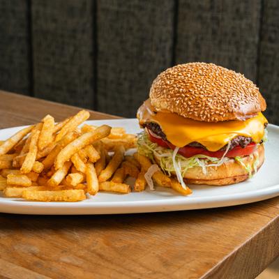 Burger with cheddar, lettuce, tomato, onion, pickle and a side of fries.