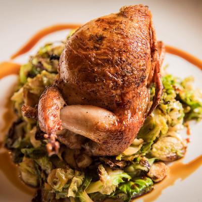 Roasted quail atop caramelized Brussels sprouts, closeup