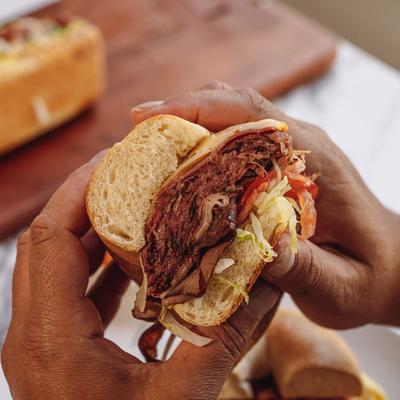 Hands holding the Triple Decker sando.